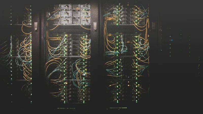 Server racks in a data centre with network cabling and status lights