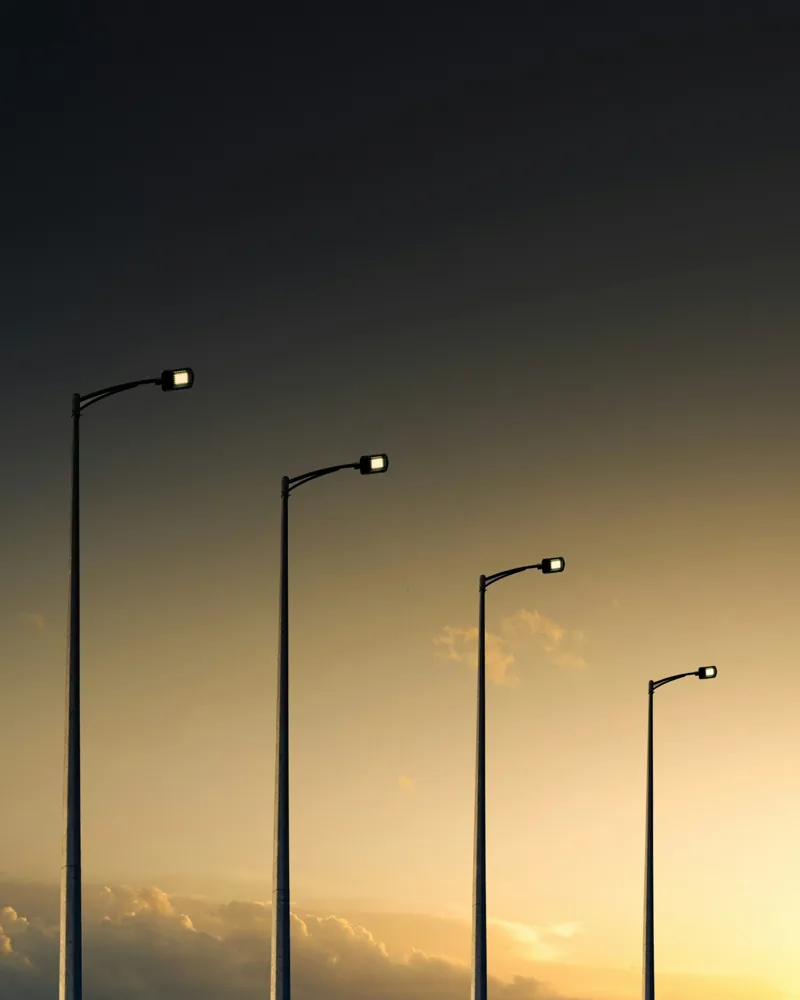 Row of street lights against an evening sky